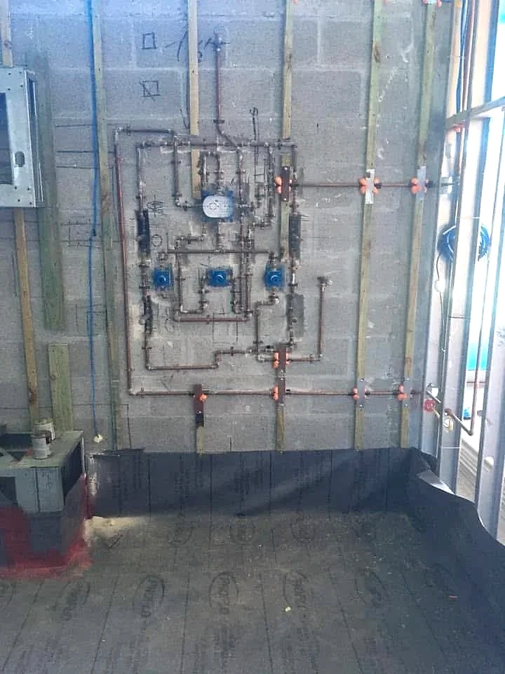 Copper water lines and shower valves roughed in on a CBS block wall, South Florida