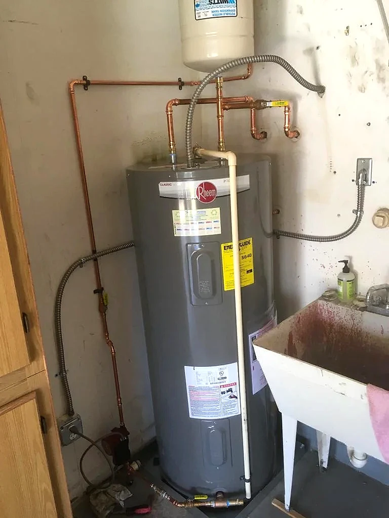 Electric tank water heater replacement with new copper connections in a utility room, South Florida