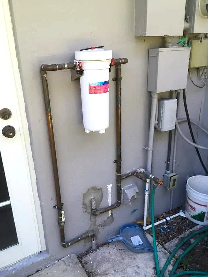 Whole-house water filter installed on the main copper supply line outside a Florida home